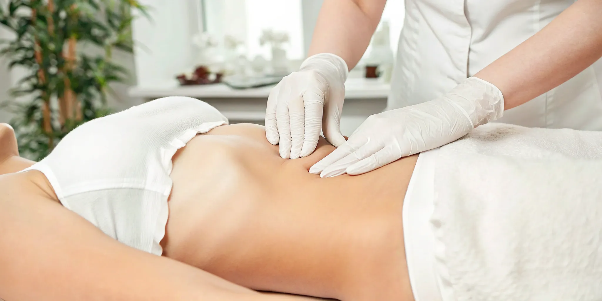 Woman's hands massaging belly for fat reduction.