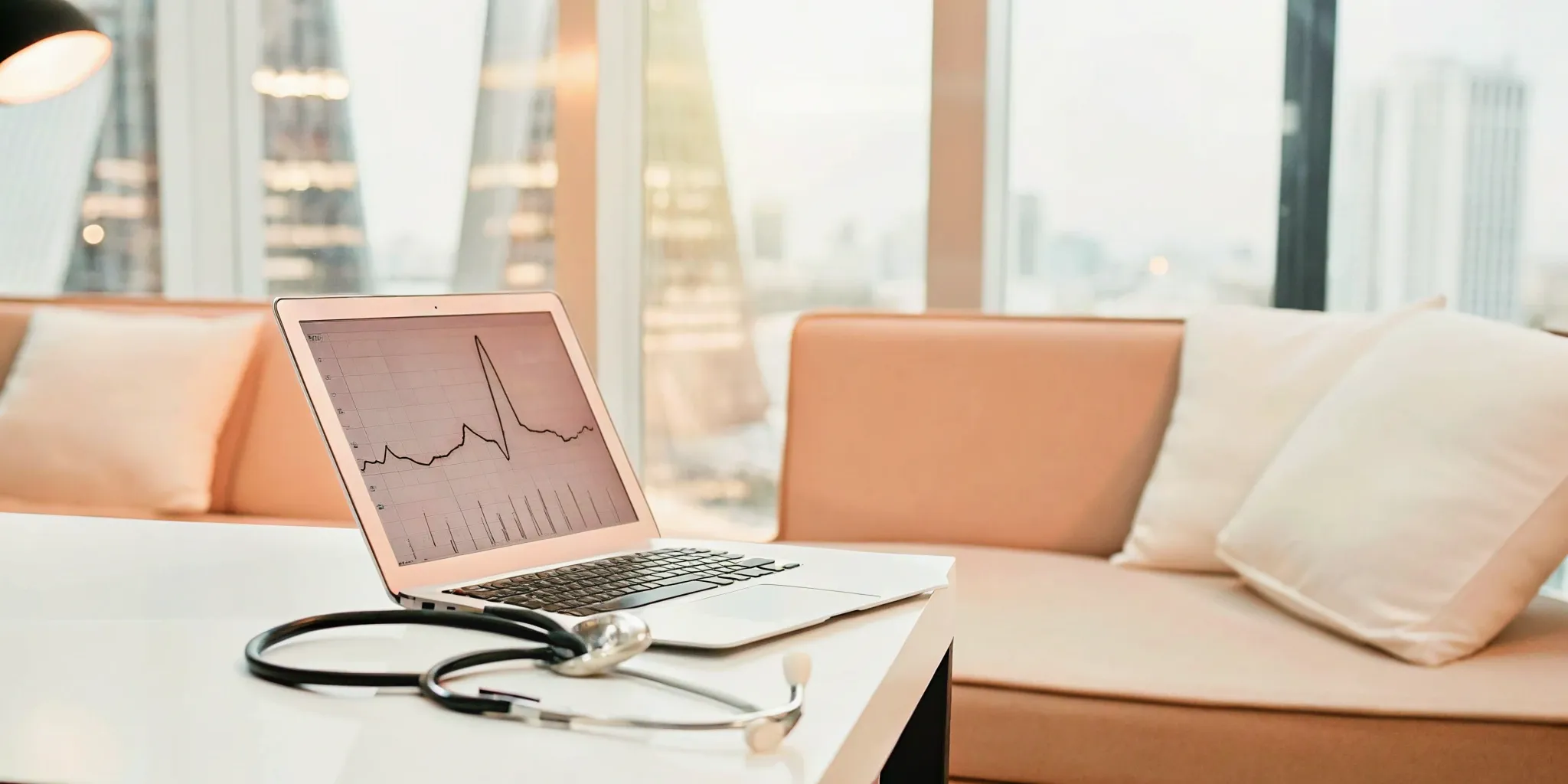Amir Baluch, MD, with stethoscope and laptop.