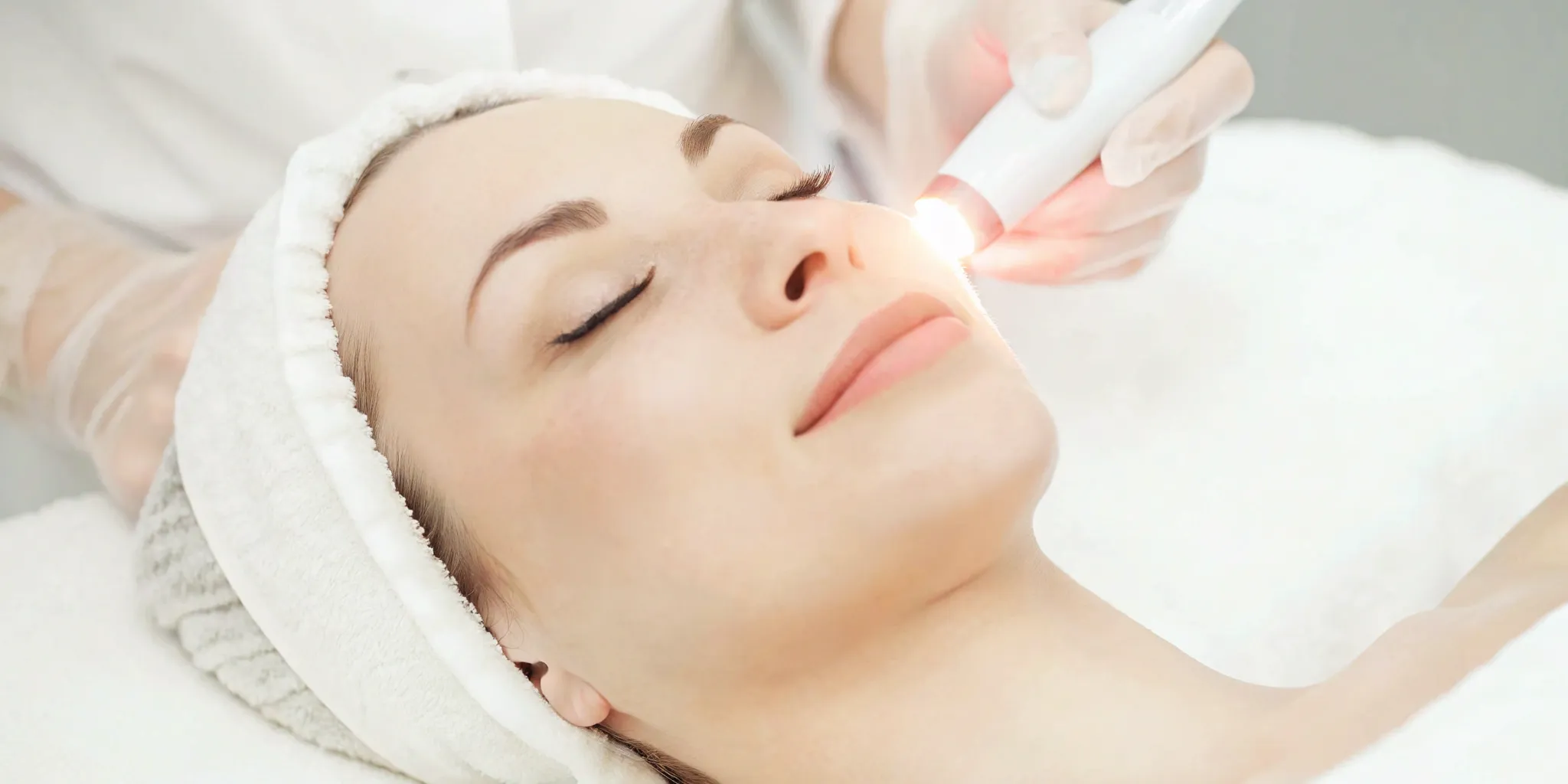 Woman getting a face laser hair removal treatment for smooth skin.