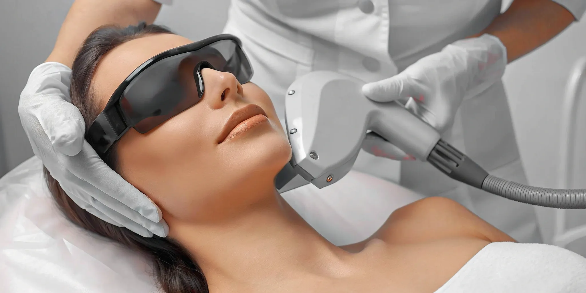 Woman getting a facial laser hair removal treatment, one of several sessions required for the face.